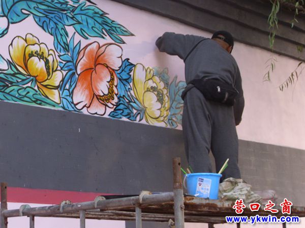 两画家在街边墙体写画宣传中华美德